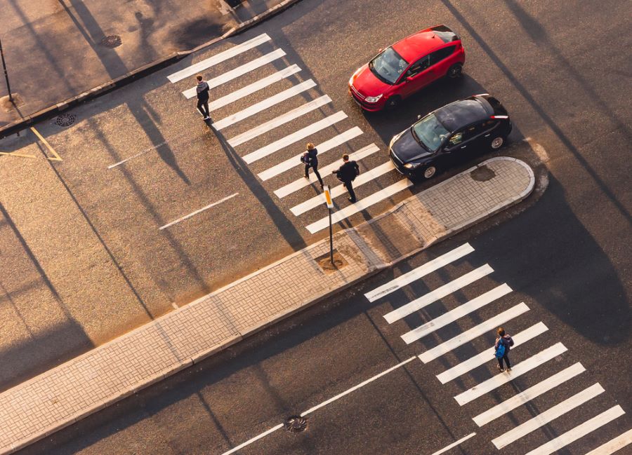 pedestrians crossing through an island in the street