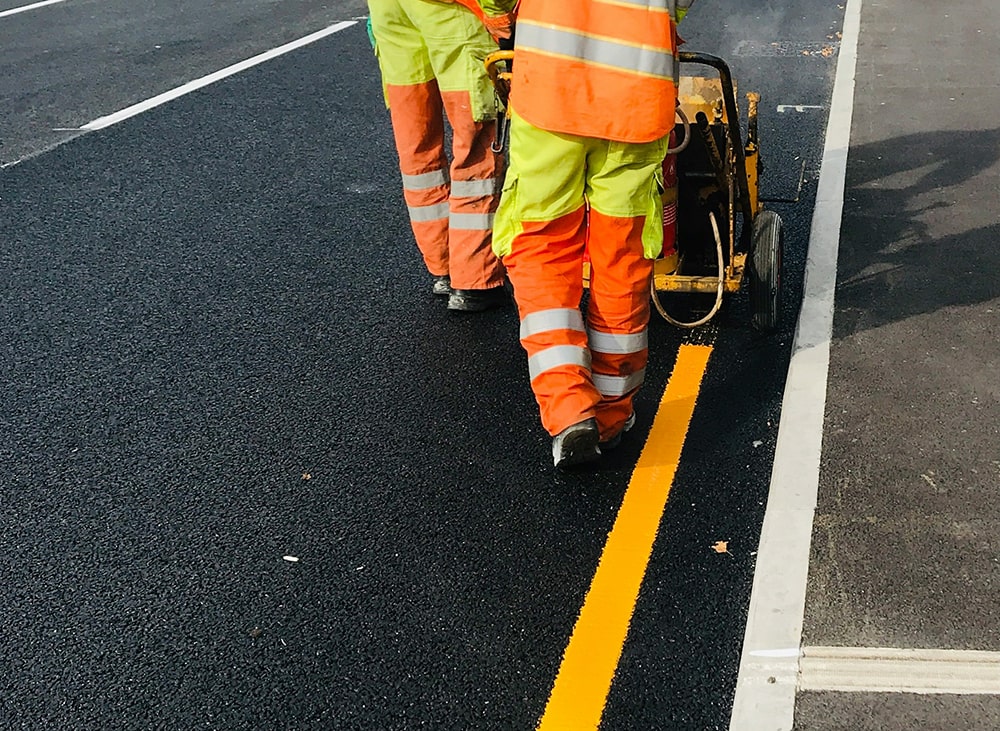 two road workers asphalt painting