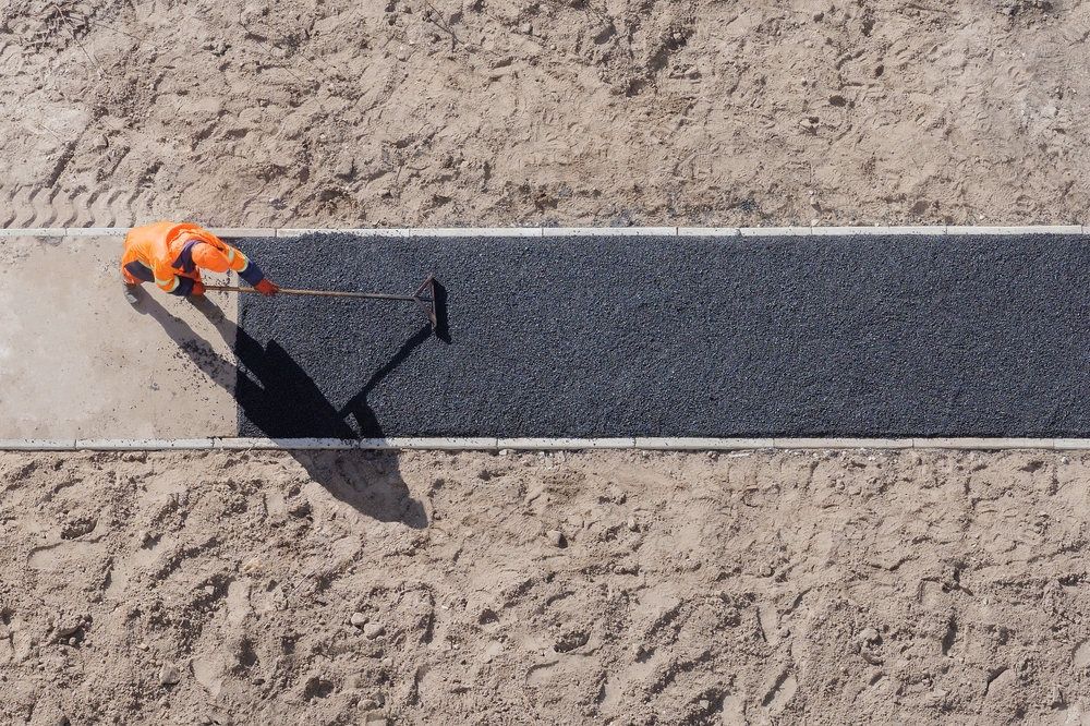 a safety road officer applying bitumen