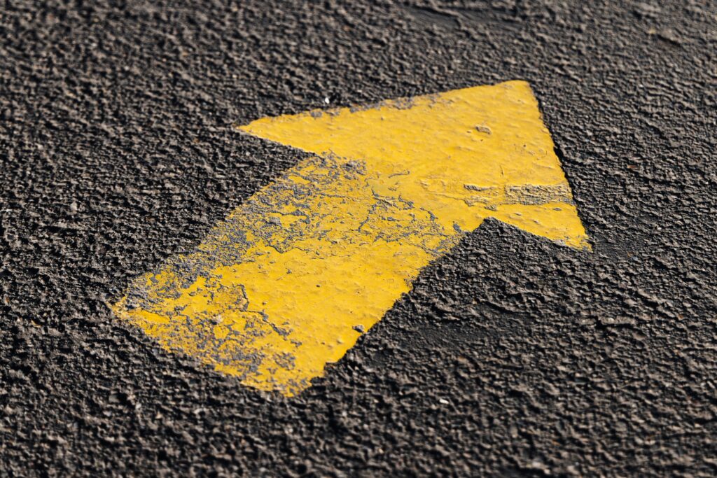 a tarnished painted arrow on an asphalt
